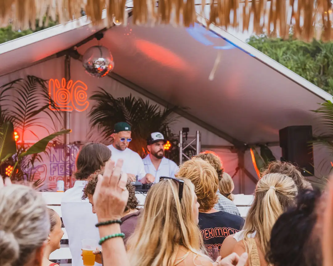 Crowd watching DJs perform at an outdoor festival
