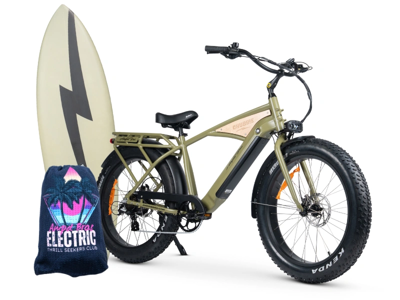 An olive-green electric fat tire bike with a mounted surfboard on the left side and a blue towel featuring a neon logo that says “Electric Thrill Seekers Club” with a palm tree and lightning bolt design.