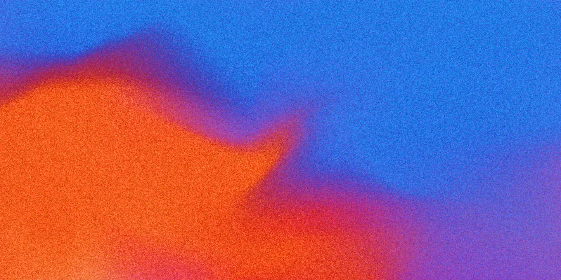 Abstract image with a bold blend of vibrant orange and red hues on the left merging into bright blue and purple tones on the right, creating a soft, gradient effect with a slightly grainy texture.