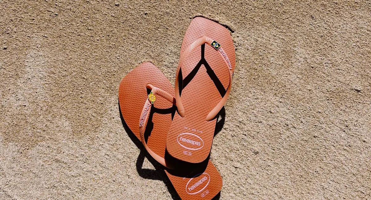 Orange flip-flops on sandy beach